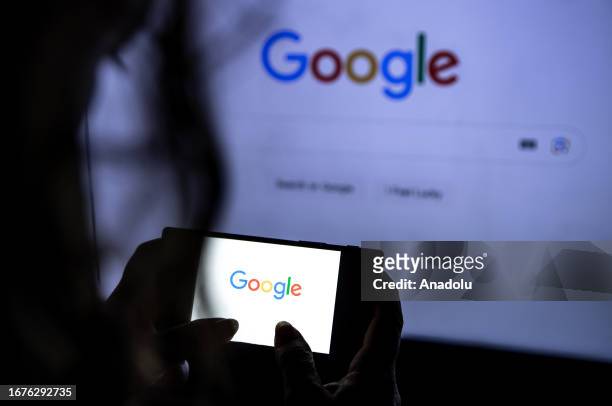 In this photo illustration, the logo of Google is displayed on the mobile phone screen in front of the logo of Google displaying on the screen in...
