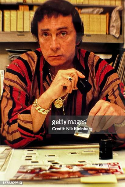 Portrait of Penthouse Magazine founder and publisher Bob Guccione , a loupe in one hand and a photo slide in the other, as he sits at a light table...