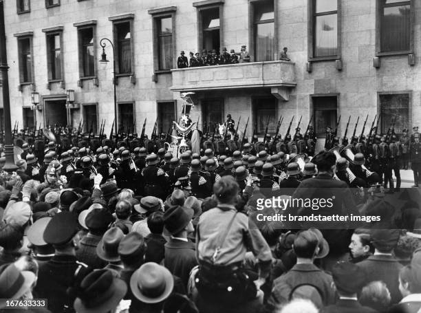 The birthday of Adolf Hitler. March of SS in front of the Reichskanzlei. On the balcony: Adolf Hitler. Berlin. April 20th 1936. Photograph....