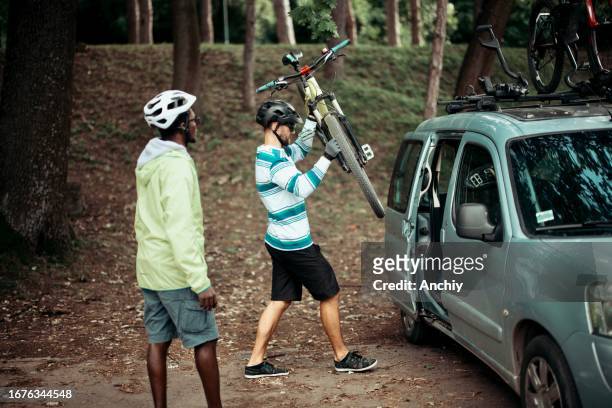 friends putting their bikes on a voiture - voiture autonome stockfoto's en -beelden