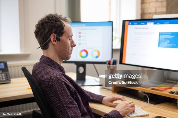 spezielle software hilft ihm bei der arbeit - hot desking arbeitsplatz stock-fotos und bilder