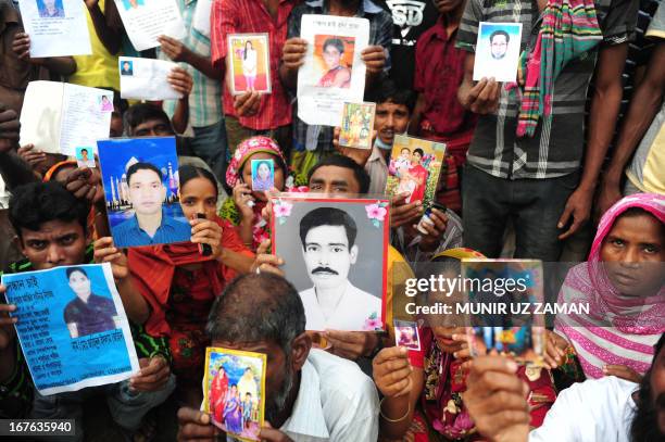 Bangladeshi relatives hold photos of the missing and dead workers three days after an eight-storey building collapsed in Savar, on the outskirts of...