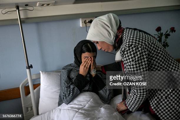 Dr Fadwa el-Fartass , a medical officer at the Benghazi Medical Centre hospital, attends to Ibrar Goma, a 15-year-old survivor of the recent flooding...