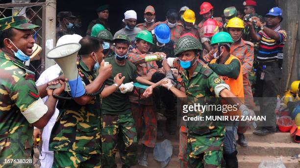 Bangladeshi army personal carry a survivor that was recovered three days after the Rana Plaza garment building collapsed in Savar, on the outskirts...