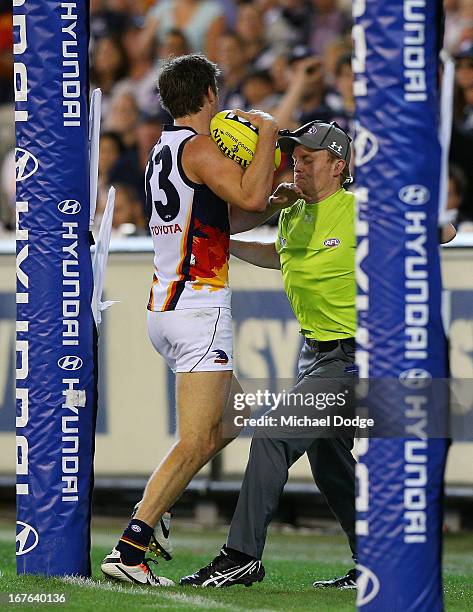 Brodie Smith of the Crows bumps into a goal umpire during the round five AFL match between the Carlton Blues and the Adelaide Crows at Melbourne...