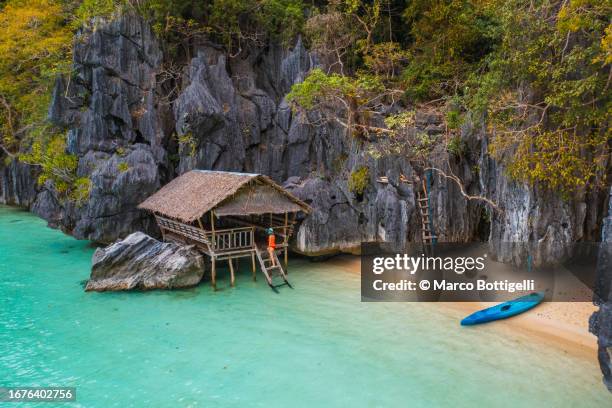 tourist on a secluded beach in coron, palawan, philippines - paalwoning stockfoto's en -beelden