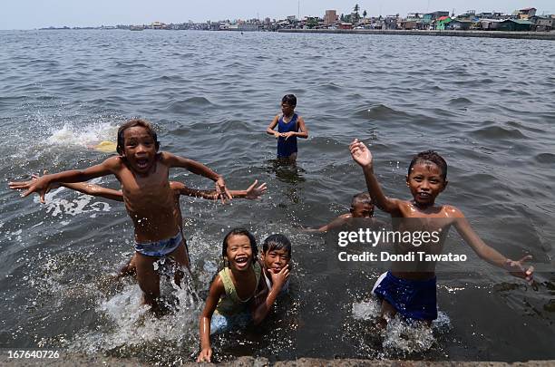 Children swim in the murky waters of Navotas de Bay on April 27, 2013 in Manila, Philippines. Despite small rainshowers, temperatures soared from 35...