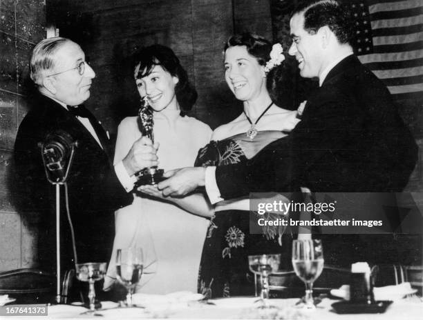 Luise Rainer and Mrs. Spencer Tracy getting the Oscar at the Academy Awards. To the left: film producer Louis B. Mayer. To the right: director Frank...