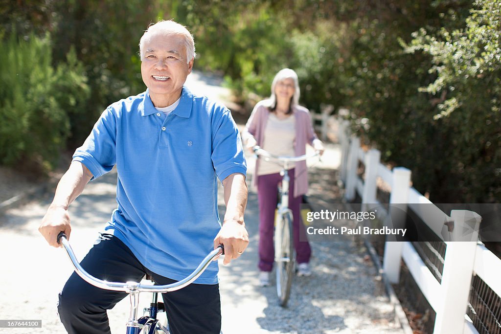 Smiling older couple riding bicycles