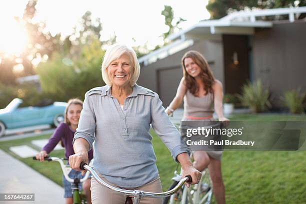 three generations of women riding bicycles - mom biking stock pictures, royalty-free photos & images