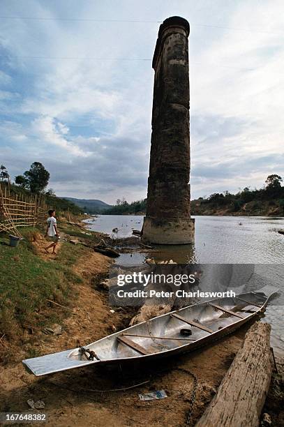 An aluminium canoe made from a downed American war plane ists next to a concrete pillar that is all that remains of a bridge near Xepone . The bridge...