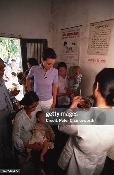 Audrey Hepburn, UNICEF's Goodwill Ambassador, visits a UNICEF sponsored child healthcare center on the outskirts of Hanoi as a nurse prepares a...