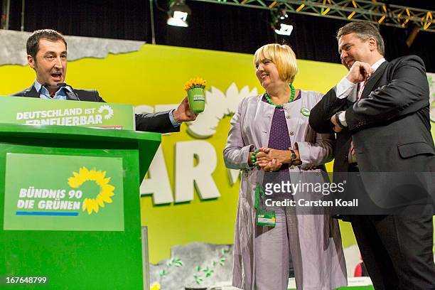 German Greens Party co-chairman Cem Oezdemir, gives a cup to guest speaker SPD Chairman Sigmar Gabriel , beside co-chairwoman Claudia Roth , on the...