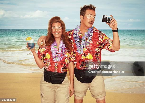 a sunburnt couple of tourists at the beach - man flower shirt fotografías e imágenes de stock