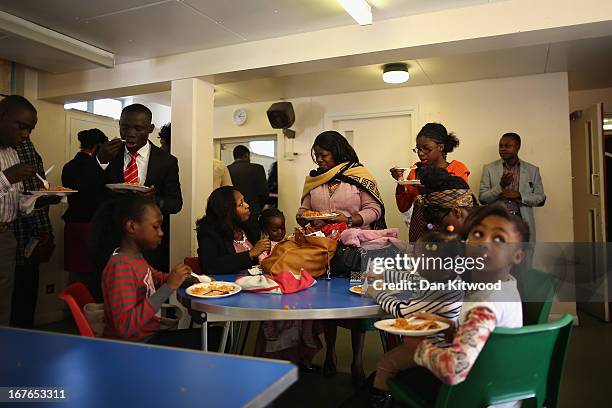 Members of the congregation enjoy a meal after a 'Seventh Day Evangelist' service at Crossway Church in the Heygate Estate on April 27, 2013 in...