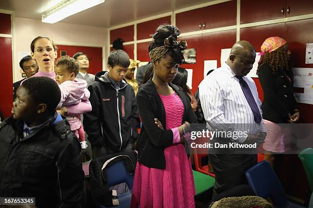 Members of the congregation prey during a 'Seventh Day Evangelist' service at Crossway Church in the Heygate Estate on April 27, 2013 in London,...