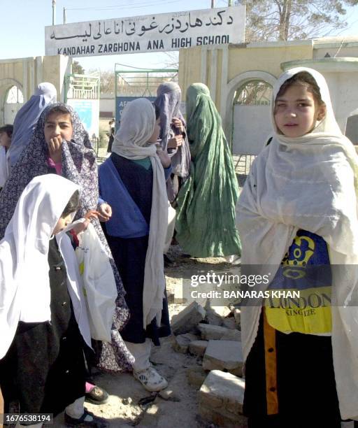 The School girls including some of them in Afghan traditional Burqa wait for their school bus after finishing school hours in the city of Kandahar,...