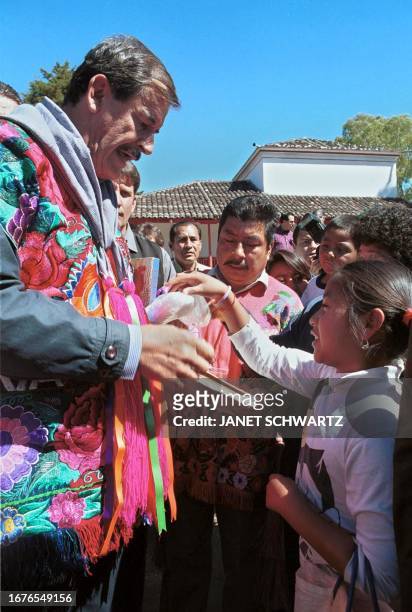 Mexican President Vicente Fox, talks to a schoolgirl in San Cristobal de las Casas, Chiapas, Mexico, 17 January 2001, before announcing a new...