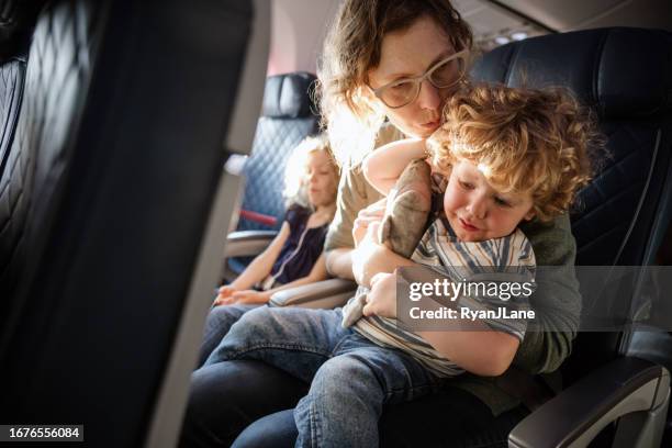 family traveling on airplane together - kid flying stock pictures, royalty-free photos & images