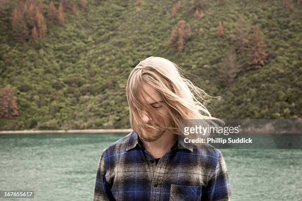 man with long hair looking down into ocean - tousled hair man stock pictures, royalty-free photos & images