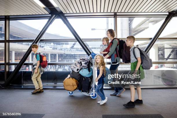 navegación familiar en el aeropuerto durante unas vacaciones - carrito-para-equipaje fotografías e imágenes de stock