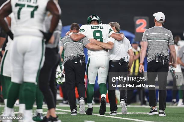 Aaron Rodgers of the New York Jets is helped off the field for an apparent injury during a game against the Buffalo Bills at MetLife Stadium on...