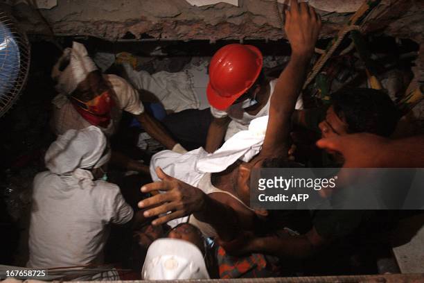 Bangladeshi rescuers carry a survivor who was recovered, on April 27, 2013 in Savar, three days after the Rana Plaza garment building collapsed....