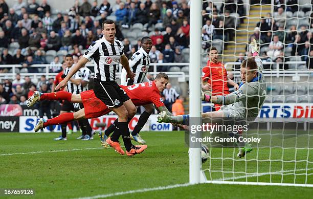 Daniel Agger of Liverpool watches a free kick by Jordan Henderson of Liverpool go past goalkeeper Rob Elliot of Newcastle United for Liverpool's...