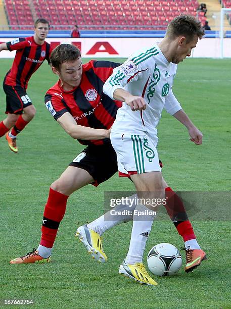 Maciej Rybus of FC Terek Grozny is challenged by Nikita Burmistrov of FC Amkar Perm during the Russian Premier League match between FC Terek Grozny...