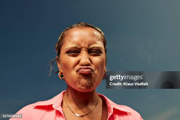 woman puckering lips against sky - grimacing stock pictures, royalty-free photos & images