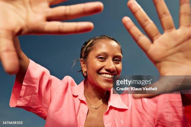 happy woman showing palms against sky - focus on background stock-fotos und bilder