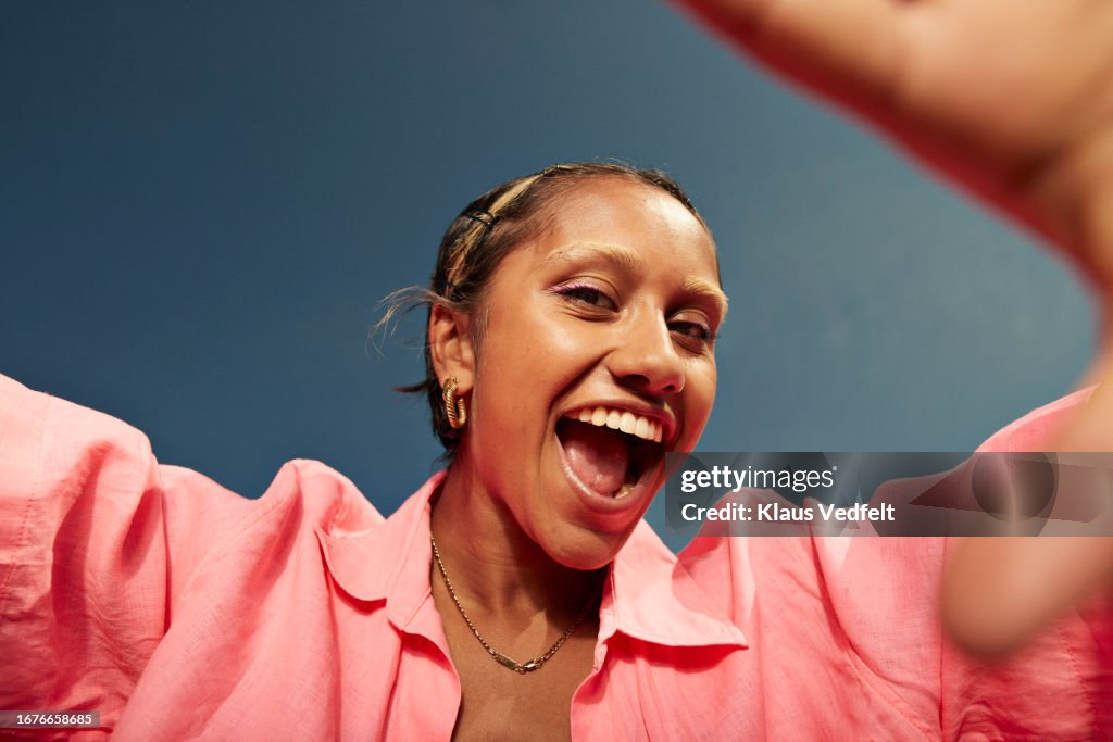 Young woman screaming against sky