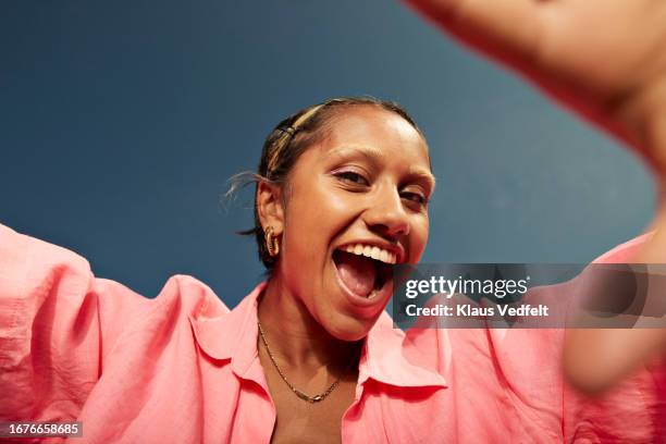 young woman screaming against sky - zufrieden stock-fotos und bilder