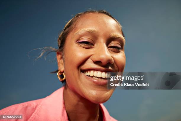 young woman with toothy smile against sky - woman smile stockfoto's en -beelden