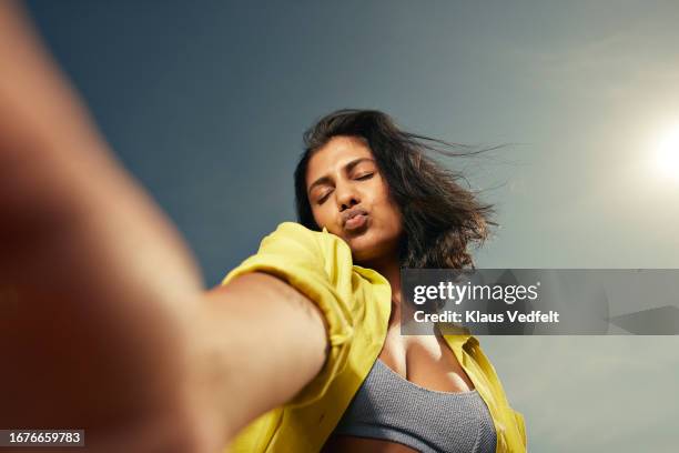 woman taking selfie against sky - female puckered lips stockfoto's en -beelden