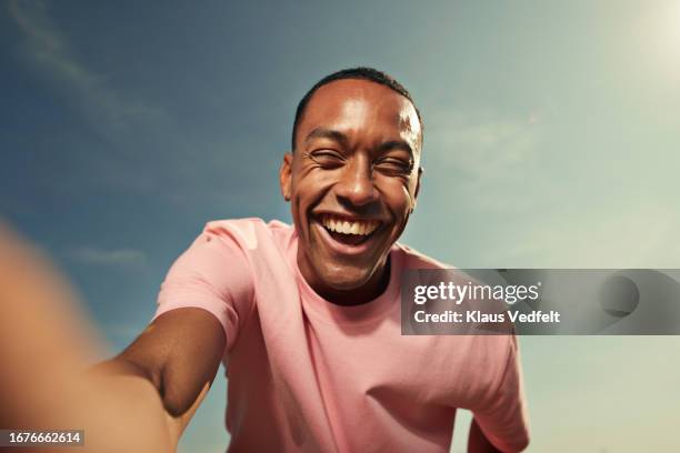 cheerful woman laughing against sky - selfie stockfoto's en -beelden