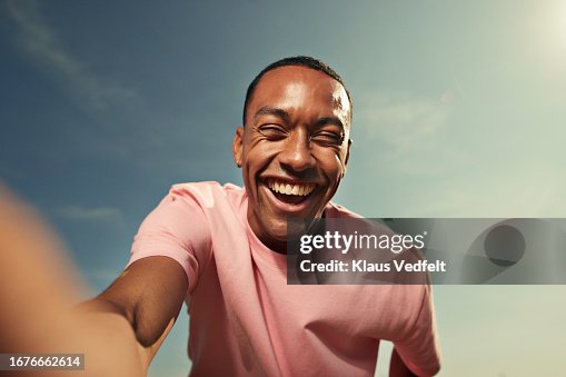 Cheerful woman laughing against sky