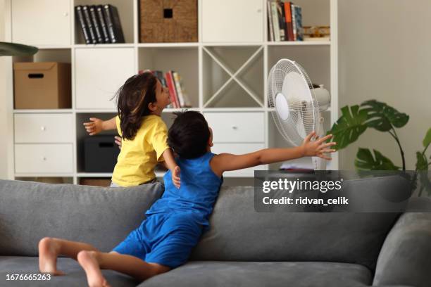 cute children is front of electric fan on hot summer day - electric fan stock pictures, royalty-free photos & images