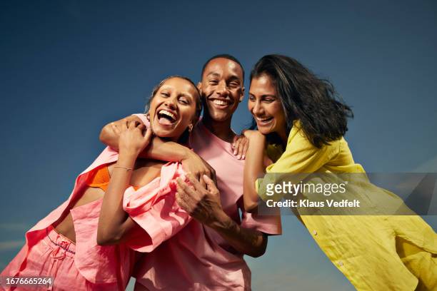 cheerful friends laughing against sky - happy people summer fashion foto e immagini stock