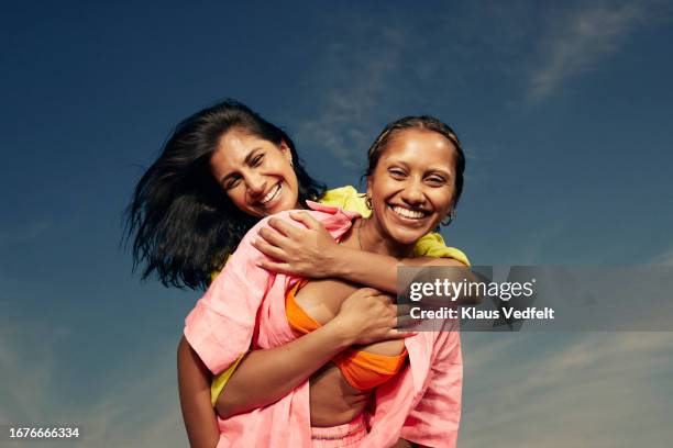 happy female friends standing against sky - lesbian pics stock pictures, royalty-free photos & images