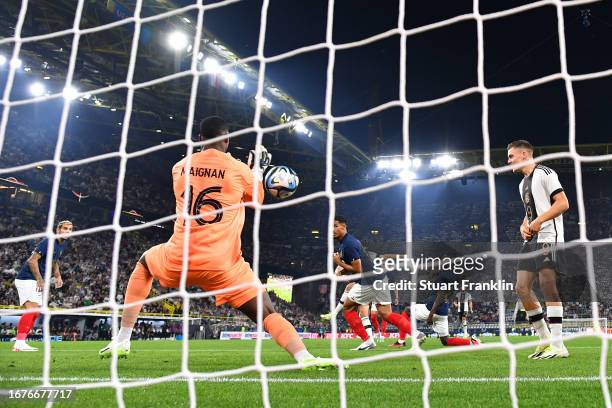 Thomas Mueller of Germany scores the team's first goal as Mike Maignan of France fails to make a save during the International Friendly match between...