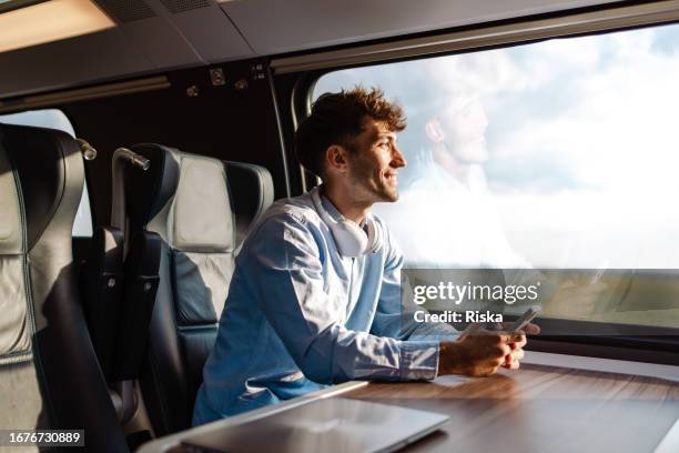 the benefit of traveling by train: admiring beautiful views without driving and in a comfortable train seat - working on laptop in train top view imagens e fotografias de stock