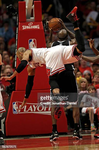 Taj Gibson of the Chicago Bulls falls over Reggie Evans of the Brooklyn Nets in Game Five of the Eastern Conference Quarterfinals in the 2013 NBA...