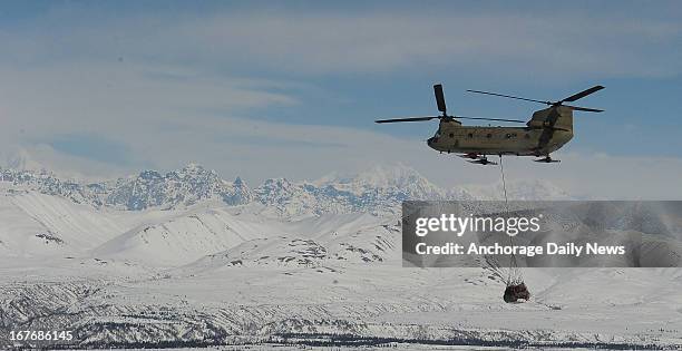 Members of B Company 1st Battalion 52 Aviation Regiment sling a load on a CH47 Chinook Helicopter from the Talkeetna, Alaska, airport to Denali base...