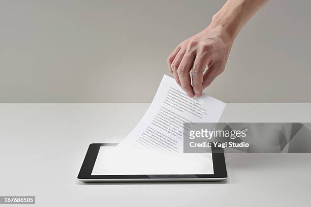 pull documents out of digital tablet - documento foto e immagini stock