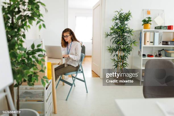 young beautiful woman using laptop at modern office - virtual coach stock pictures, royalty-free photos & images