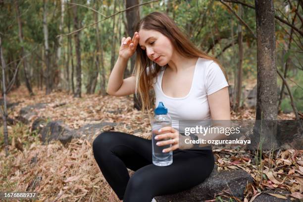young woman tired, suffering from heart attack while doing sport ,runningning - agony in the garden stockfoto's en -beelden