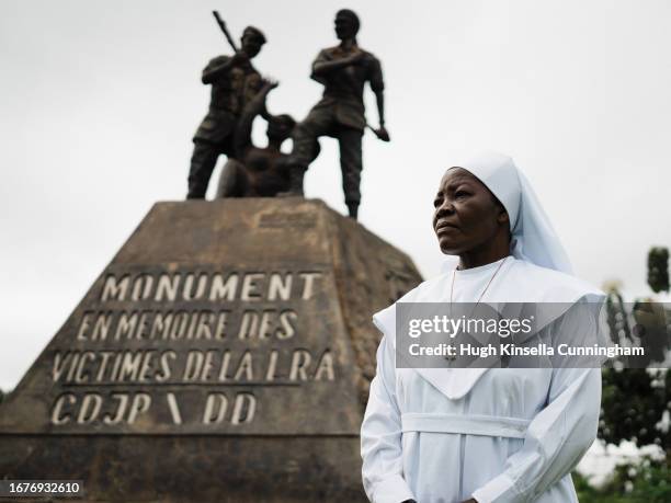 Sister Angelique Namaika poses for a portrait beside a memorial to victims of the Lord's Resistance Army on September 17, 2023 in Dungu, Congo....