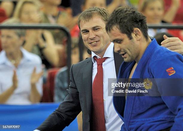 Former World champion and Russian coach, Vitaly Makarov, congratulates Kirill Denisov of Russia on leaving the mat after he won the u90kgs title...