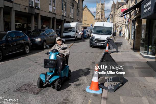 Gentleman on his mobility scooter on Dyer Street on 13th September 2023 in Cirencester, United Kingdom. Cirencester is a market town in...